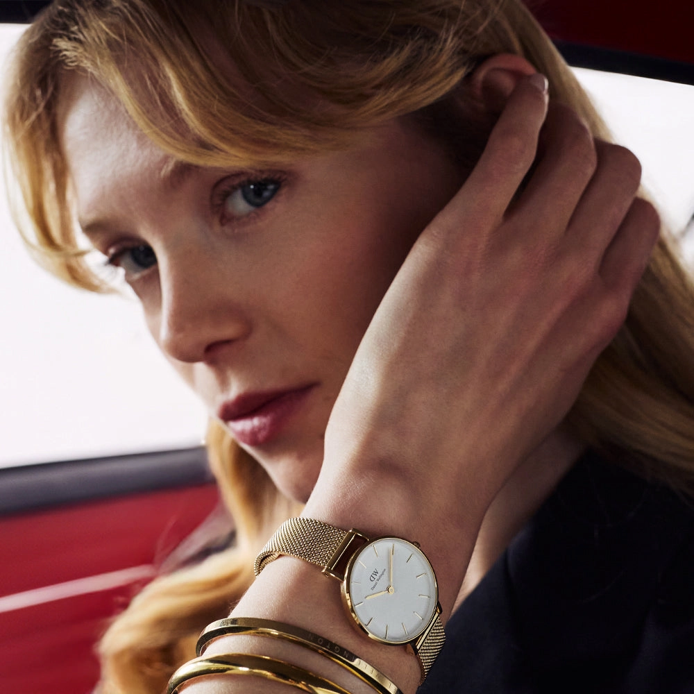 Woman resting her head on her hand, wearing a watch and stacked bracelets