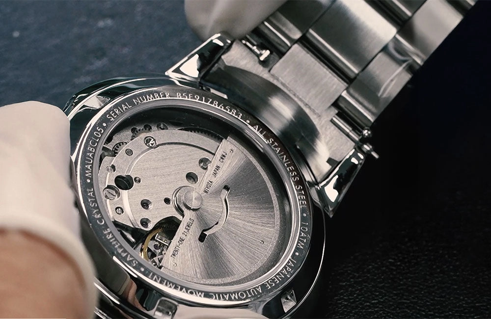 Automatic watch article photograph with a wrist and a dark strap